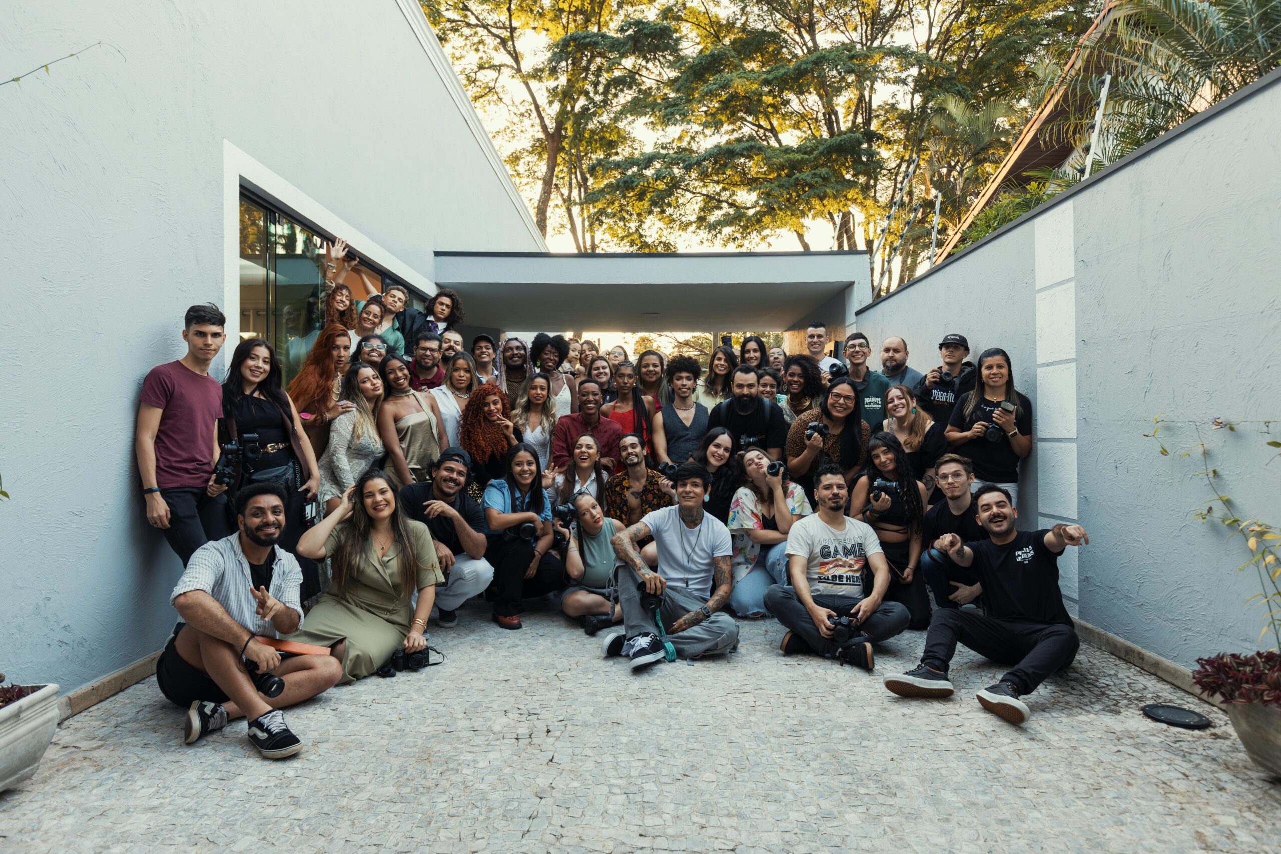 A diverse crowd of adults gathered outdoors, showcasing teamwork and camaraderie in a casual environment.